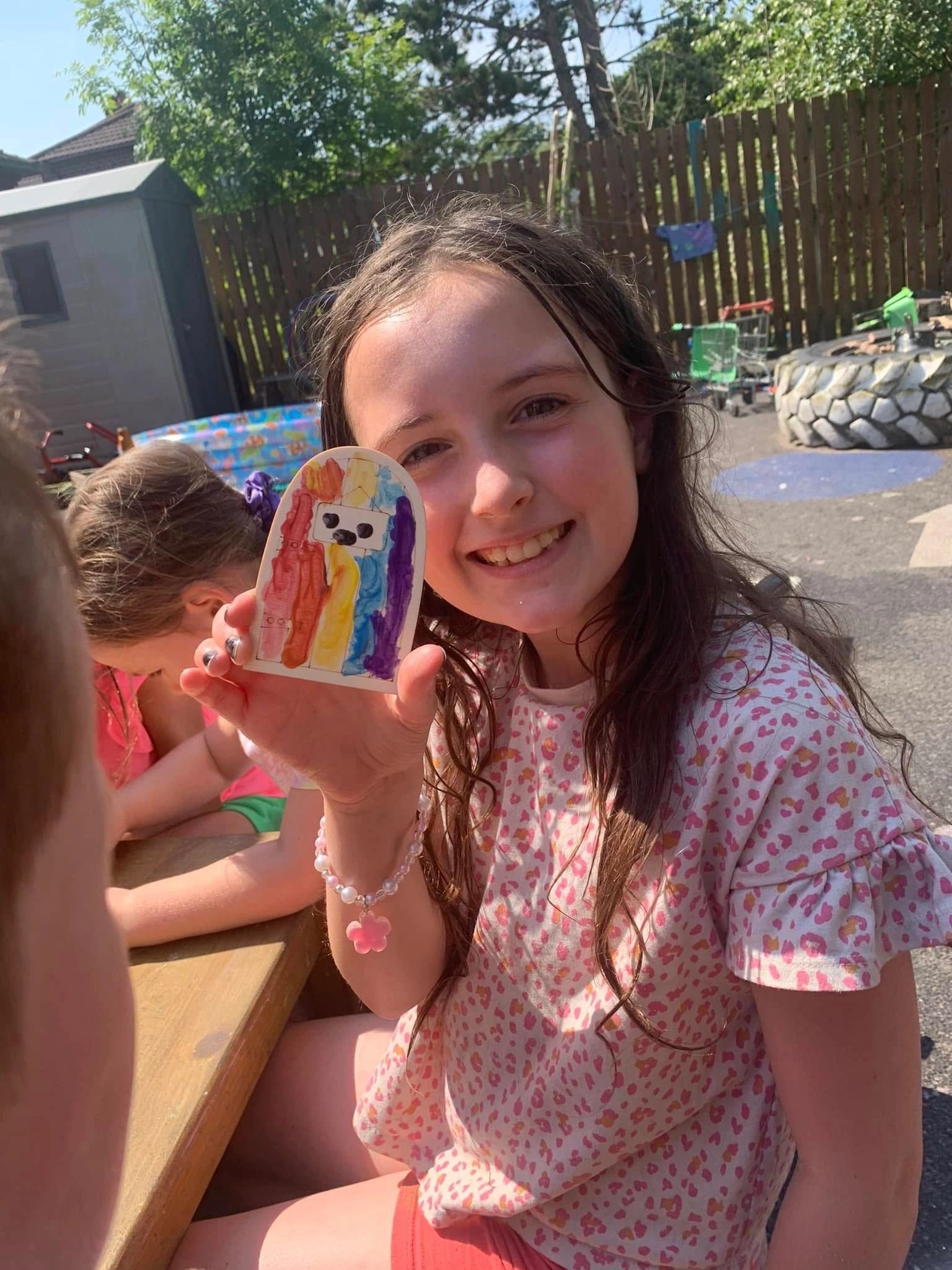 A child at holiday club holding a painted craft