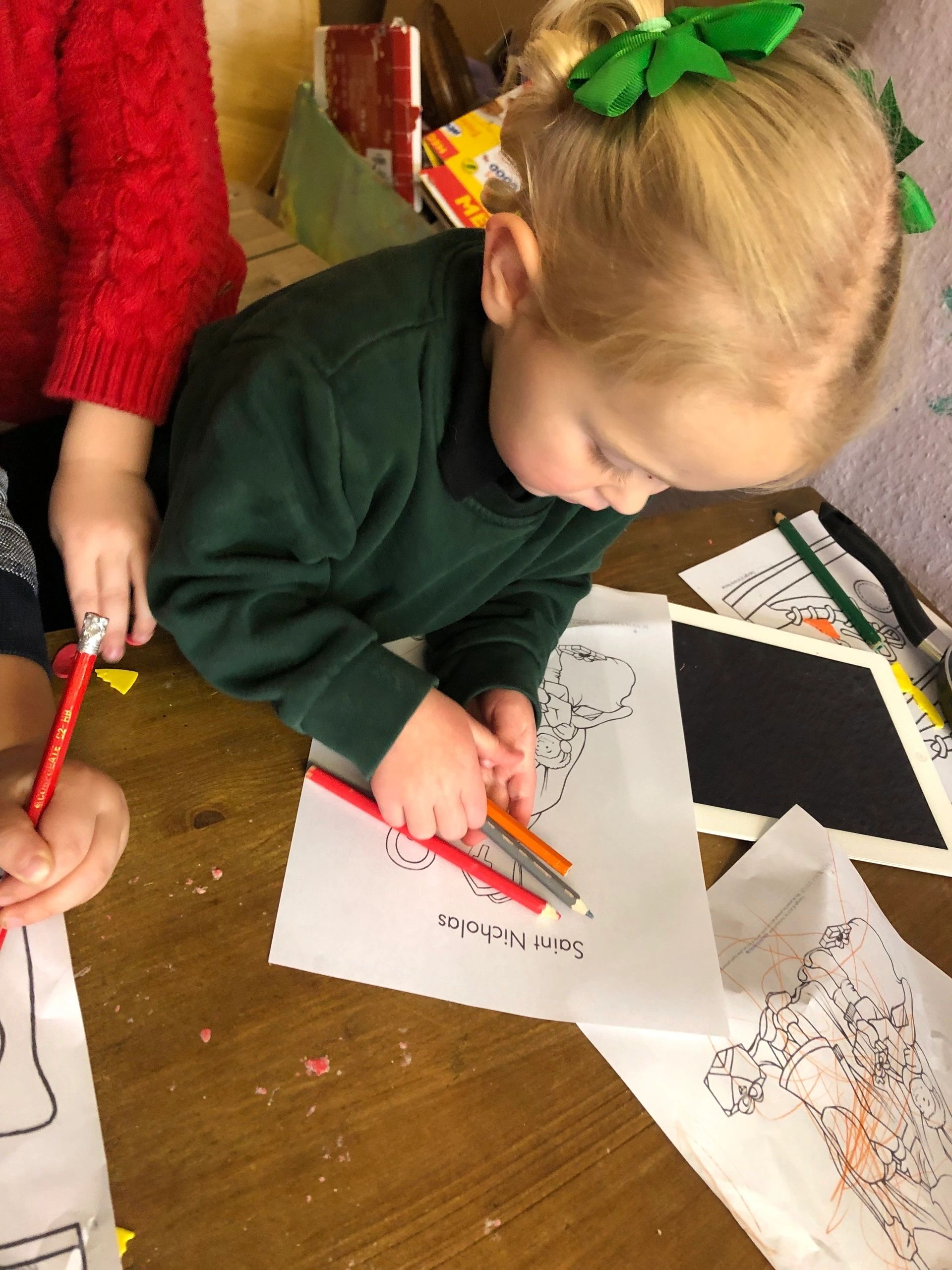 A young child drawing at a table in the nursery
